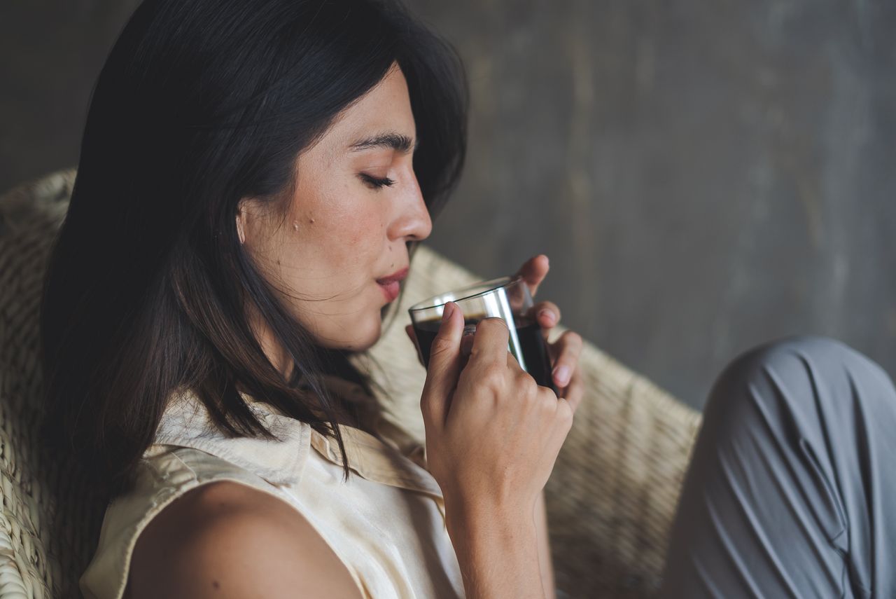 The Art of Drawing Readers In: Your attractive post title goes here Woman savoring a cup of coffee while relaxing in a cozy chair indoors.